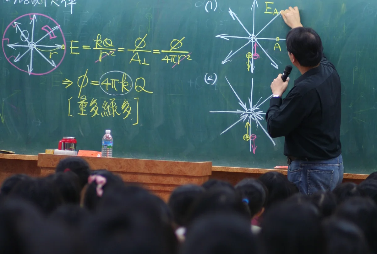 魏宏泰在黑板前授課，學生坐在教室內學習